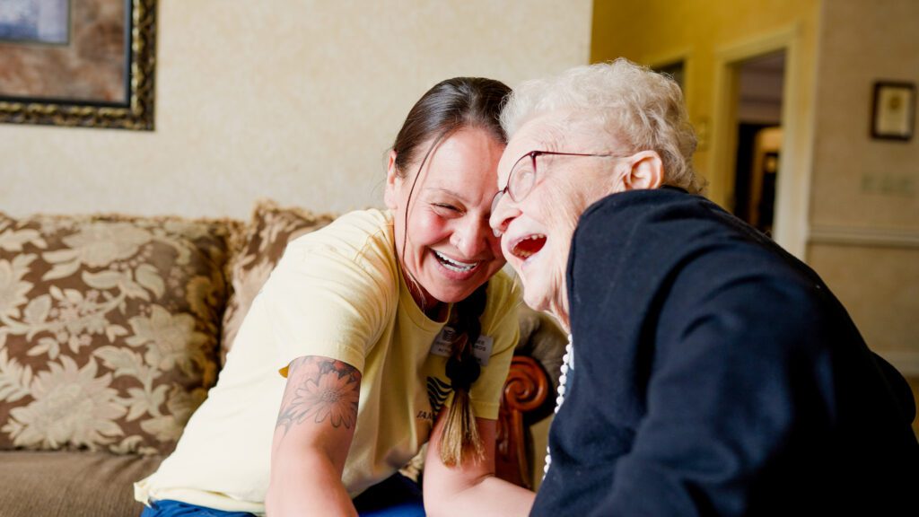 A woman and nurse laugh in a long term care facility
