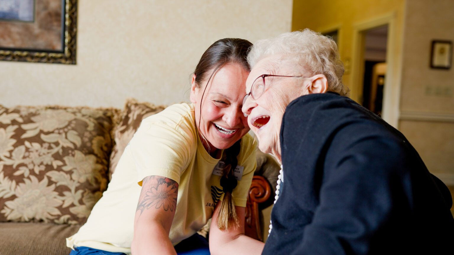 A woman and nurse laugh in a long term care facility