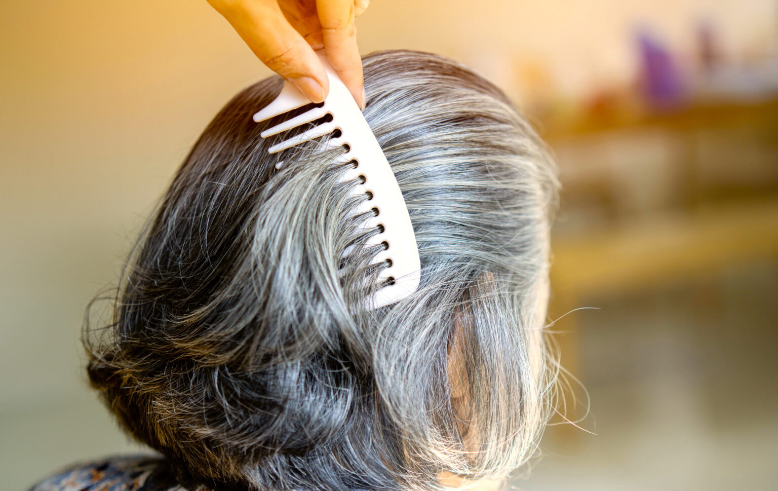 A woman gets her hair brushed at a salon at a skilled nursing facility
